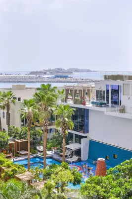 an aerial view of a hotel with a pool and palm trees at Maison Privee - Glamourous Apt with Sea Views at FIVE Palm in Dubai