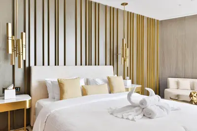 a bedroom with a white bed with a stuffed animal on it at Maison Privee - Glamourous Apt with Sea Views at FIVE Palm in Dubai