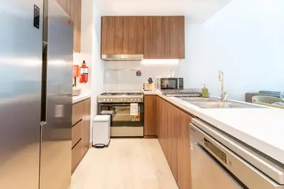 a kitchen with a stainless steel refrigerator and a sink at Stunning 2BR Apartment in Port De La Mer in Dubai