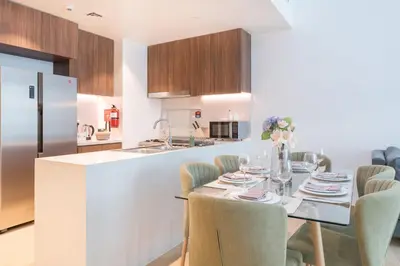 a kitchen and dining room with a table and chairs at Stunning 2BR Apartment in Port De La Mer in Dubai