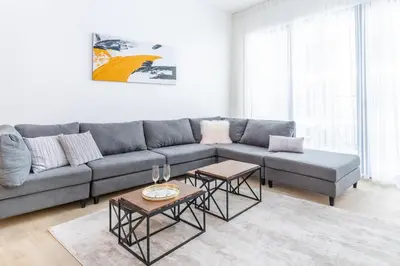 a living room with a couch and two tables at Stunning 2BR Apartment in Port De La Mer in Dubai