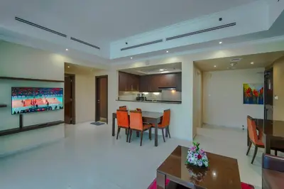 a dining room and living room with a table and chairs at Icon Delux Hotel Apartments Al Barsha - Formerly Abidos in Dubai
