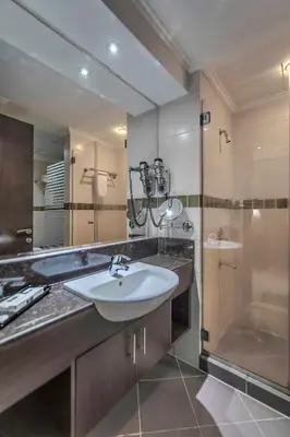 a bathroom with a sink and a shower and a mirror at Icon Delux Hotel Apartments Al Barsha - Formerly Abidos in Dubai