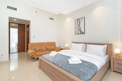 a bedroom with a large bed and a couch at 1bd apt plus study I Close to mall I Fast wi-fi in Dubai