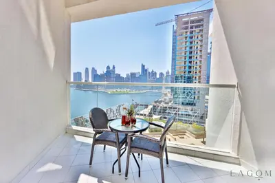 a table and chairs on a balcony with a view of the city at Winds of the Canal by Lagom - Business Bay Dubai in Dubai