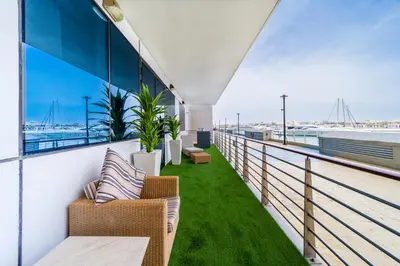 a balcony with chairs and a view of the ocean at 2 Bedroom App with private beach and infinity pool in Dubai
