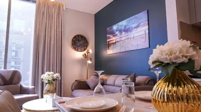 a living room with a table with a vase of flowers at STAY La Casa Da Vinci 1BR Holiday Home CVR B3002 near Burj Khalifa in Dubai