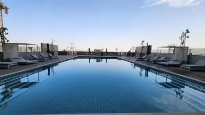 a large swimming pool with lounge chairs on a building at STAY La Casa Da Vinci 1BR Holiday Home CVR B3002 near Burj Khalifa in Dubai