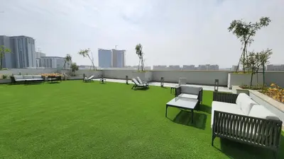 a rooftop patio with benches and grass on a building at STAY La Casa Da Vinci 1BR Holiday Home CVR B3002 near Burj Khalifa in Dubai