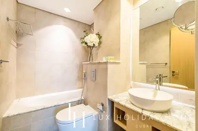 a bathroom with a sink and a toilet and a tub at LUX Paramount Burj View Business Bay in Dubai