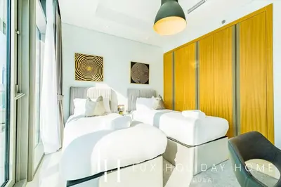 two beds in a room with a window at LUX Paramount Burj View Business Bay in Dubai