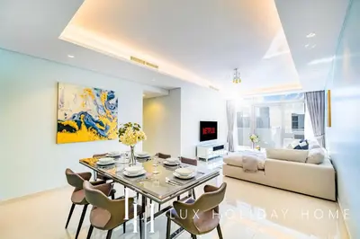 a living room with a dining table and a couch at LUX Paramount Burj View Business Bay in Dubai