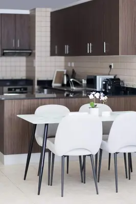a white table and chairs in a kitchen at High Floor Elegance,Prime Location-Close to tram in Dubai
