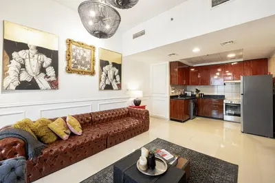 a living room with a couch and a kitchen at Beautiful home, Magnificent view in Dubai