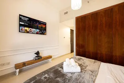 a bedroom with a bed and a tv on the wall at Beautiful home, Magnificent view in Dubai