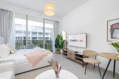 a white room with a bed and a table at Work & Relax & Chill in JVC in Dubai