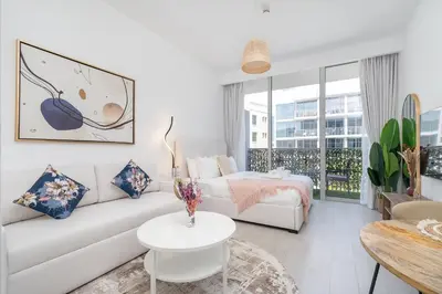 a white living room with a couch and a table at Work & Relax & Chill in JVC in Dubai