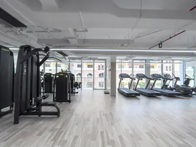 a gym with rows of treadmills and ellipticals at Work & Relax & Chill in JVC in Dubai