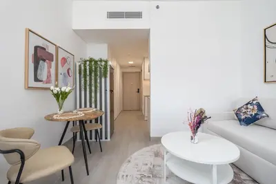 a living room with a white couch and a table at Work & Relax & Chill in JVC in Dubai