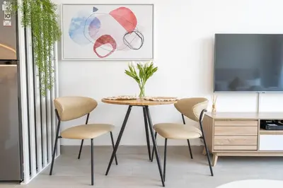 a dining room with a table with chairs and a tv at Brand New Vibrant Studio in JVC in Dubai