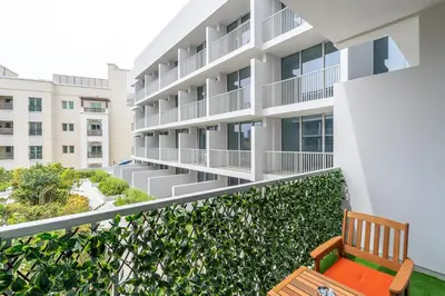 an apartment balcony with a bench and a building at Bright & Modern Studio in JVC in Dubai