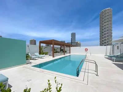 a swimming pool on the roof of a building at Bright & Modern Studio in JVC in Dubai