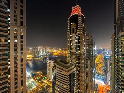 a night view of a city with tall buildings at Relax & Unwind in This Cozy 2BR Apartment in Dubai