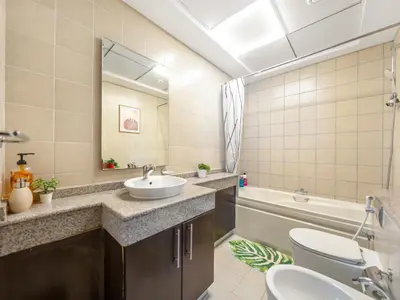a bathroom with a sink and a toilet and a tub at Relax & Unwind in This Cozy 2BR Apartment in Dubai