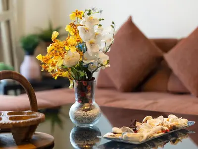 a vase of flowers on a table with a plate of popcorn at Relax & Unwind in This Cozy 2BR Apartment in Dubai