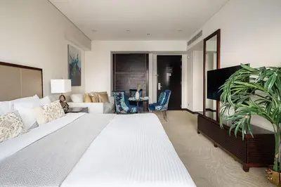 a bedroom with a large bed and a living room at Frank Porter - Emaar Residences Dubai Marina in Dubai