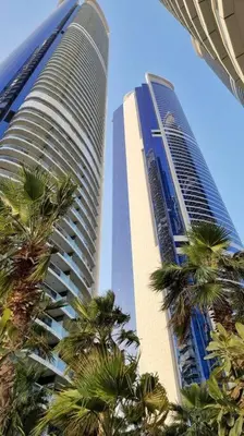 two tall buildings with palm trees in front of them at Amazing Paramount Hotel apartment D48 in Dubai
