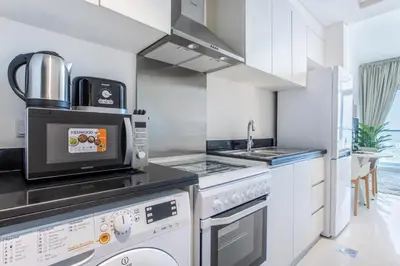 a kitchen with a stove and a sink at Full Golf View Studio in Damac Hills - Host & Stay in Dubai