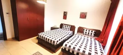 a bedroom with two beds and a door at 2BR Jumeirah Beach front Residence in Dubai