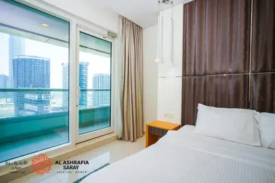 a bedroom with a bed and a large window at Alashrafia Saray - Superb 1 BR in Canal Views in Dubai