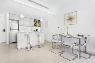 a kitchen with a table and chairs and a refrigerator at Frank Porter - Al Ghozlan 4 in Dubai