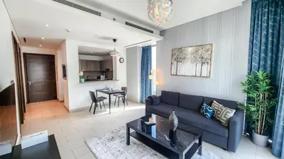 a living room with a couch and a table at STAY BY LATINEM Luxury 1BR Holiday Home G61024 near Burj Khalifa in Dubai
