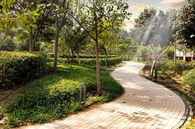 a walkway in a park with trees and flowers at STAY BY LATINEM Luxury 1BR Holiday Home G61024 near Burj Khalifa in Dubai