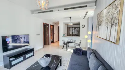 a living room with a couch and a tv at STAY BY LATINEM Luxury 1BR Holiday Home G61024 near Burj Khalifa in Dubai