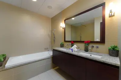 a bathroom with a tub and a sink and a mirror at Maison Privee - Splendid Apt on The Palm with Stunning Sea Views in Dubai