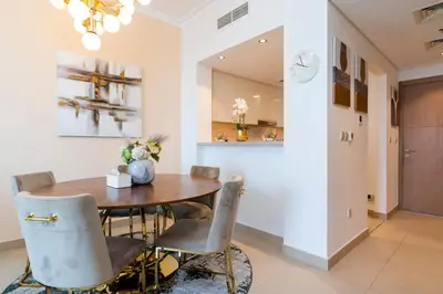 a dining room with a wooden table and chairs at Prestige Living 1BR with Full Burj Khalifa View by Auberge in Dubai