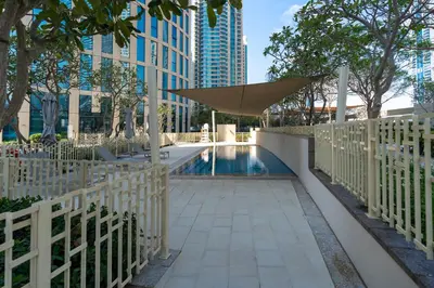 a pool with a umbrella and a building at Prestige Living 1BR with Full Burj Khalifa View by Auberge in Dubai