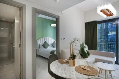 a living room with a table and a bedroom at EasyGo - Affordable 1br Close to Public Transit - Zad-13 in Dubai