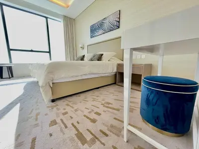 a bedroom with a bed and a blue trash can at LHG PALM JUMEIRAH Tallest RoofTop Pool in Dubai