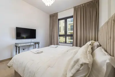 a white bedroom with a bed and a window at Apartment with Partial Sea View in La Mer in Dubai
