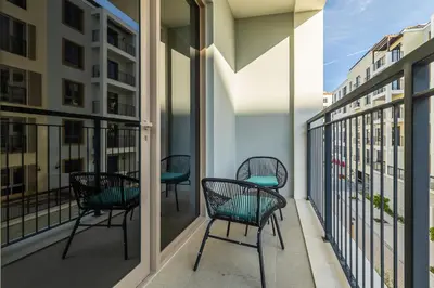 a balcony with chairs and tables on a building at Apartment with Partial Sea View in La Mer in Dubai