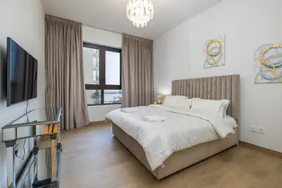 a bedroom with a bed and a flat screen tv at Apartment with Partial Sea View in La Mer in Dubai