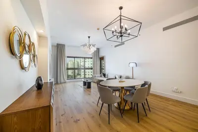 a dining room and living room with a table and chairs at Apartment in Golden Mile with access to Fairmont in Dubai