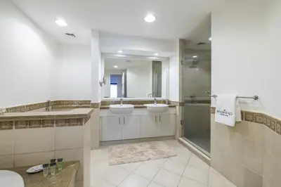 a large bathroom with two sinks and a shower at Apartment in Golden Mile with access to Fairmont in Dubai
