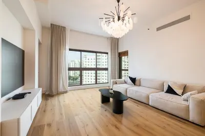 a living room with a couch and a tv and a table at Apartment in Golden Mile with access to Fairmont in Dubai