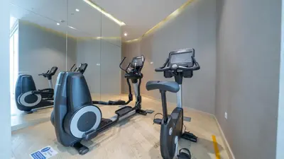 a gym with three exercise bikes in a room at Bright Deluxe Studio canal view - Special offer in Dubai
